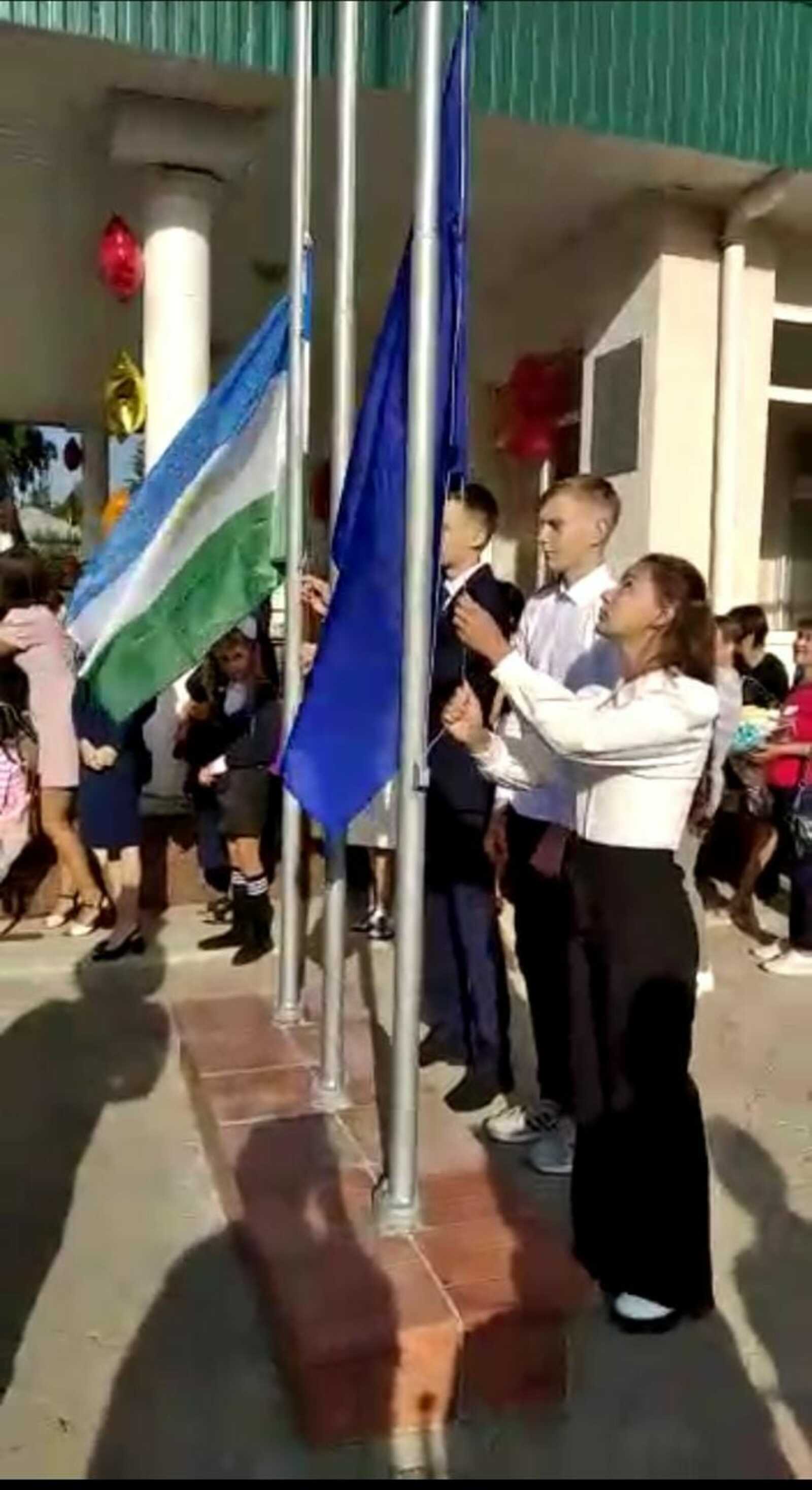 Мәктәптәрҙә уҡыусылар гимн тыңлай, флаг күтәрә